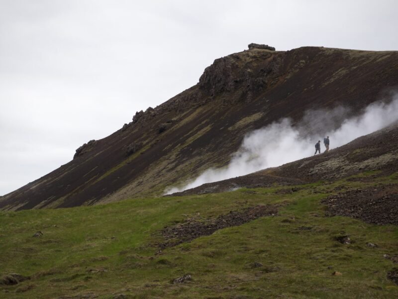 Two hikers crossing a rocky hillside in a national park.