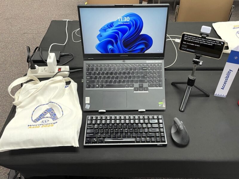 Workplace setup with a laptop, external keyboard, mouse, and phone.